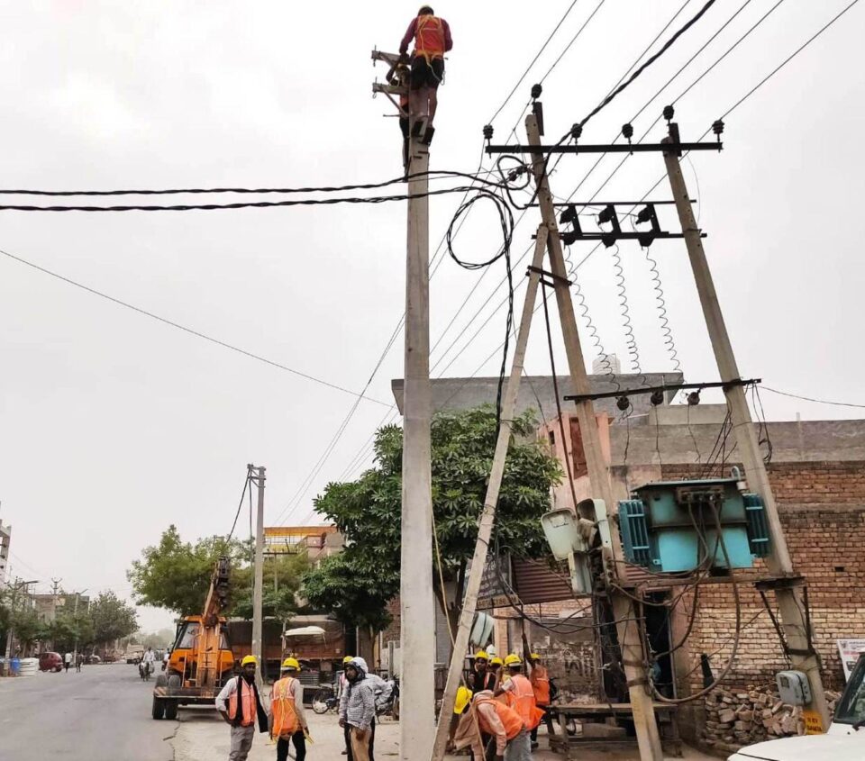फोटो-अतिरिक्त फीडर के लिए महम रोड पर नई बिजली लाइन लगाते हुए कर्मचारी।