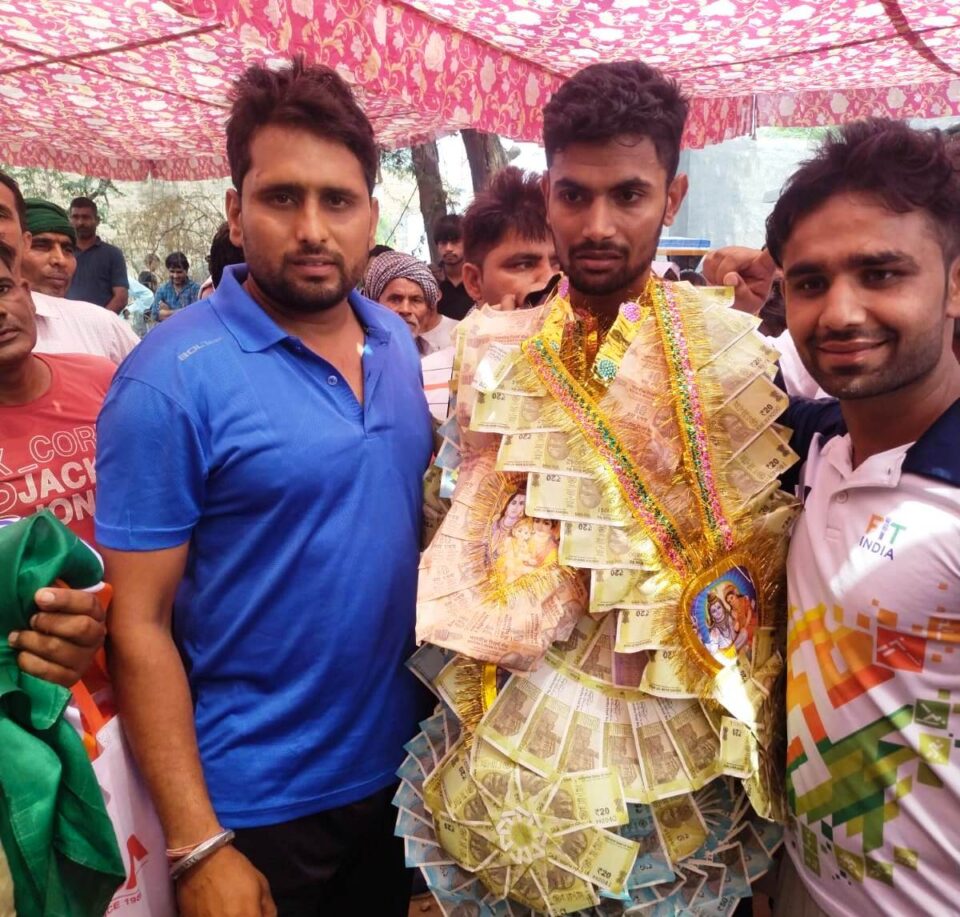 फोटो-गोल्ड पदक विजेता खिलाडी को सम्मानित करते हुए कोच राजेश मलिक