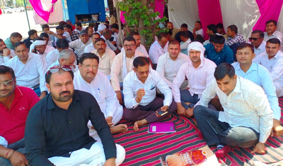 फोटो- गोहाना सिटी सब डिविजन के सामने धरने पर बैठे बिजली कर्मचारी।
